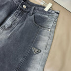 Dark blue denim pants with button fly, front pockets, and Prada logo patch