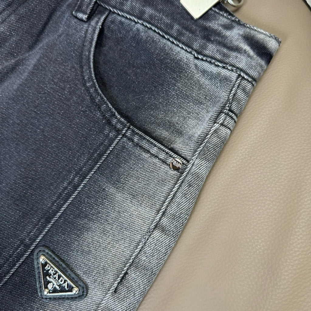 Dark blue denim pants close-up of curved front pocket and zipper detail