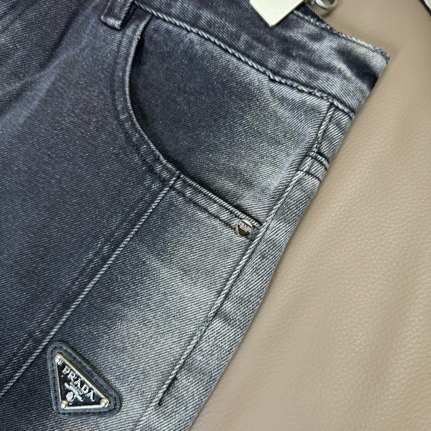 Dark blue denim pants close-up of curved front pocket and zipper detail