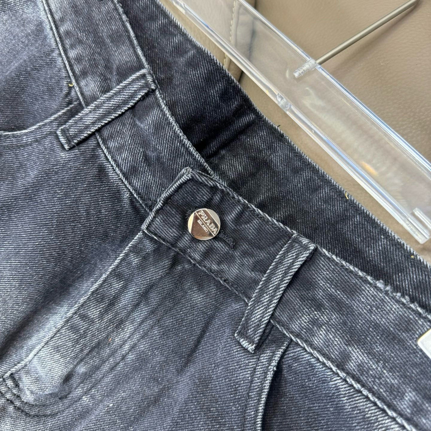 Denim pants close-up of waistband button and stitched belt loops