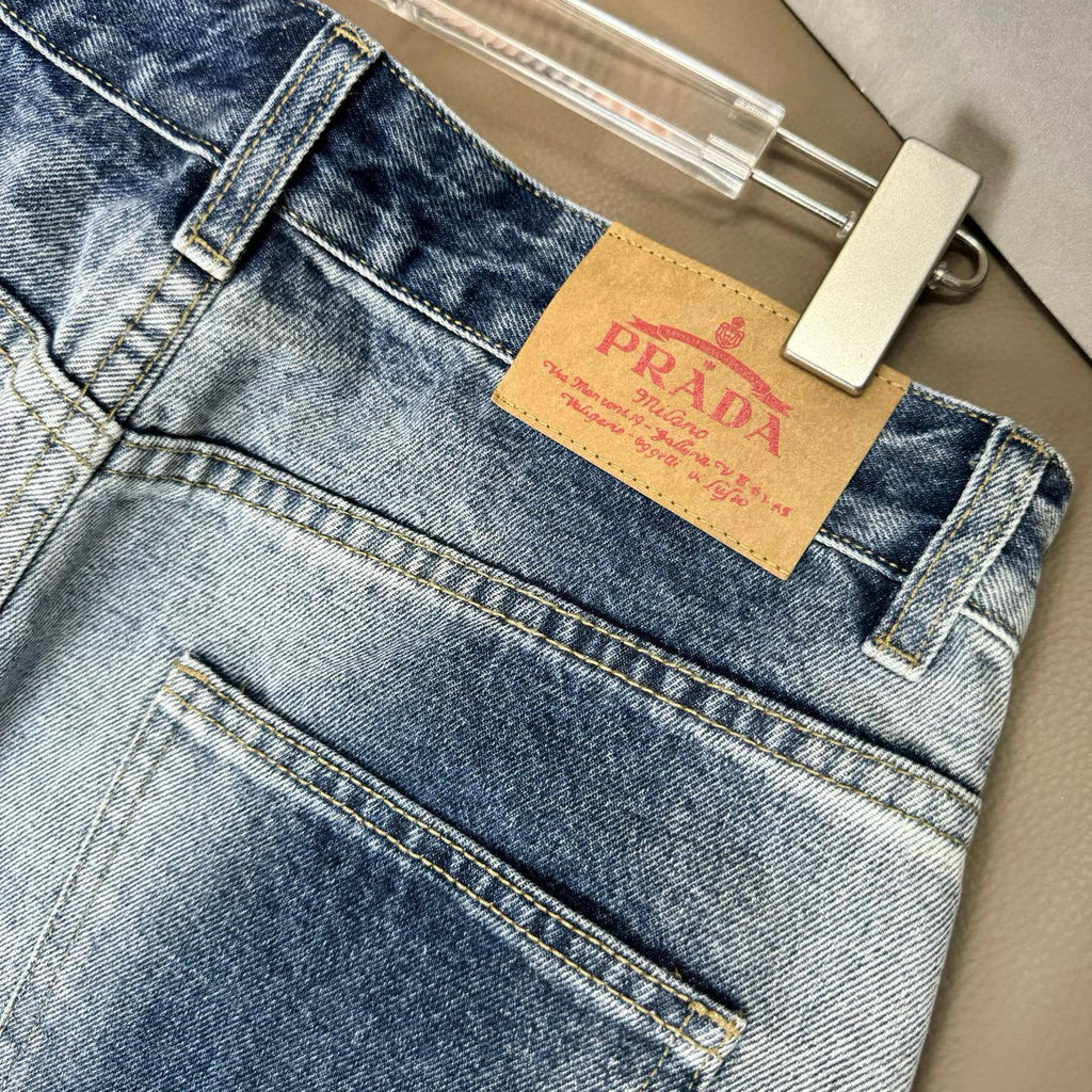 Light blue denim pants close-up of front fly area and PRADA logo patch