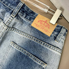 Light blue denim pants close-up of front fly area and PRADA logo patch