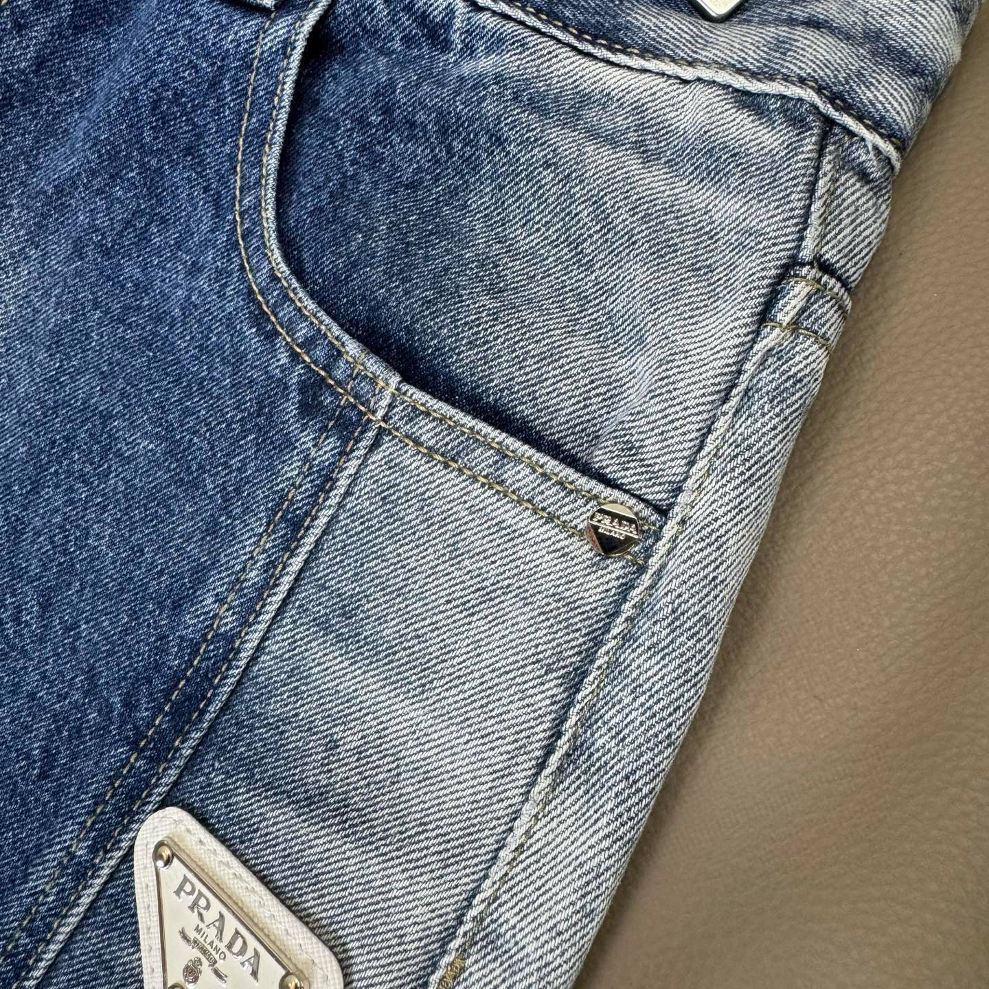 Light blue denim pants close-up of pocket stitching and small logo patch