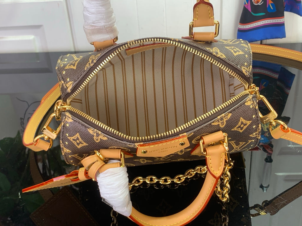 Louis Vuitton monogram handbag open top showing striped lining and gold zipper, interior view