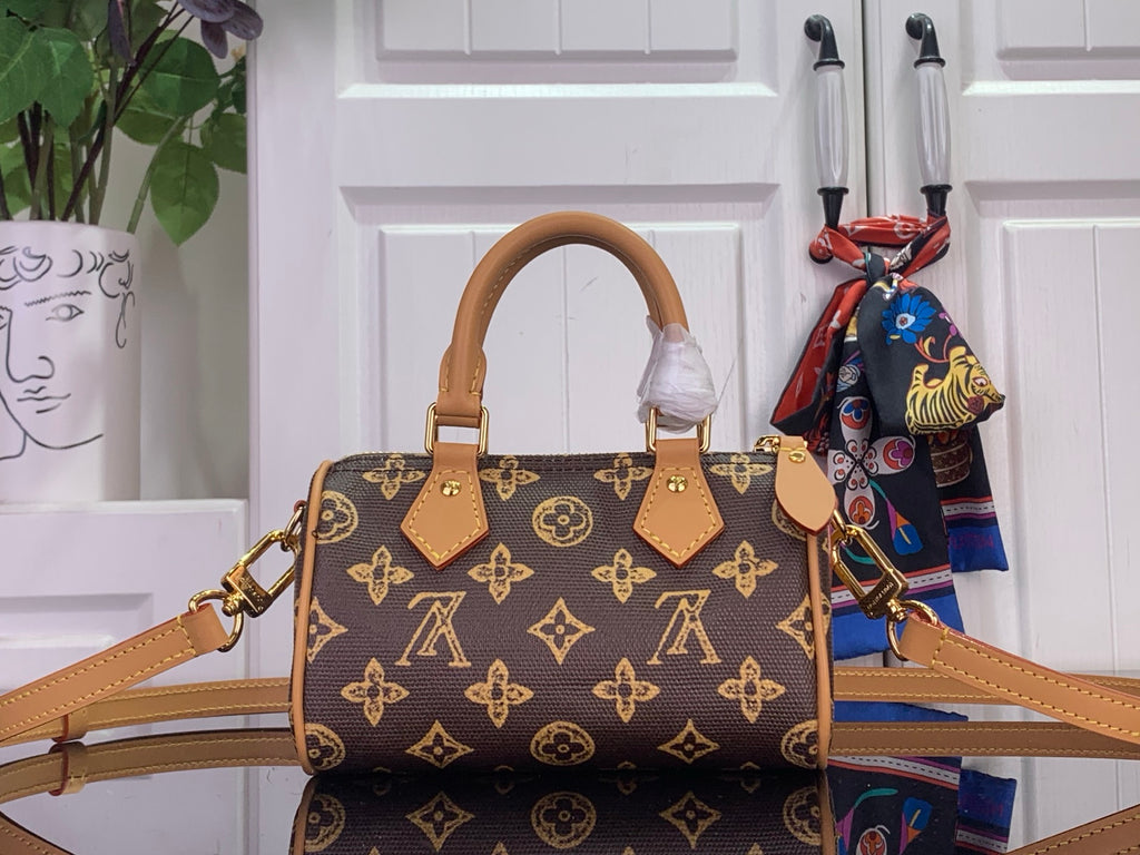 Monogram handbag with tan top handles, structured body, brown and gold repeating logo pattern.