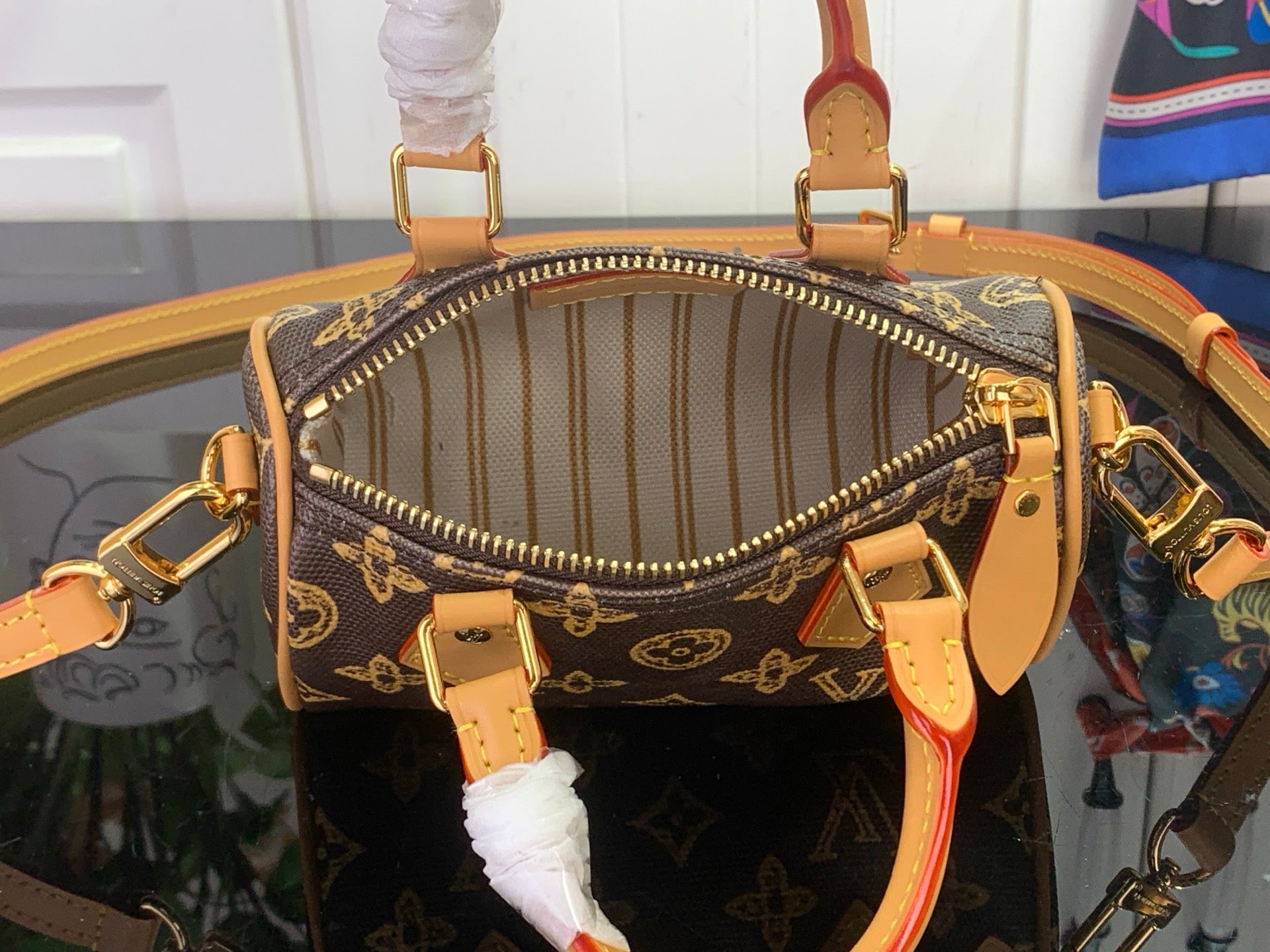 Zippered monogram handbag opening with tan lining and gold hardware, showing inside pocket.
