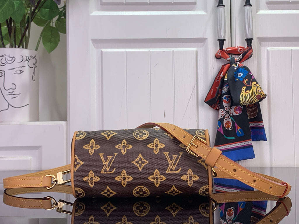 Monogram handbag with tan shoulder strap and top handles, brown and gold repeating pattern.