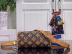 Monogram handbag with tan shoulder strap and top handles, brown and gold repeating pattern.