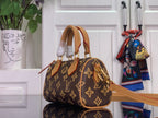 Monogram handbag with short top handles and tan trim, brown and gold repeating logo pattern.