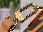 Gold-tone clasp hardware with leather strap on monogram bag, brown and tan tones.