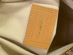 Louis Vuitton interior label on beige lining with embossed logo and tan stitching
