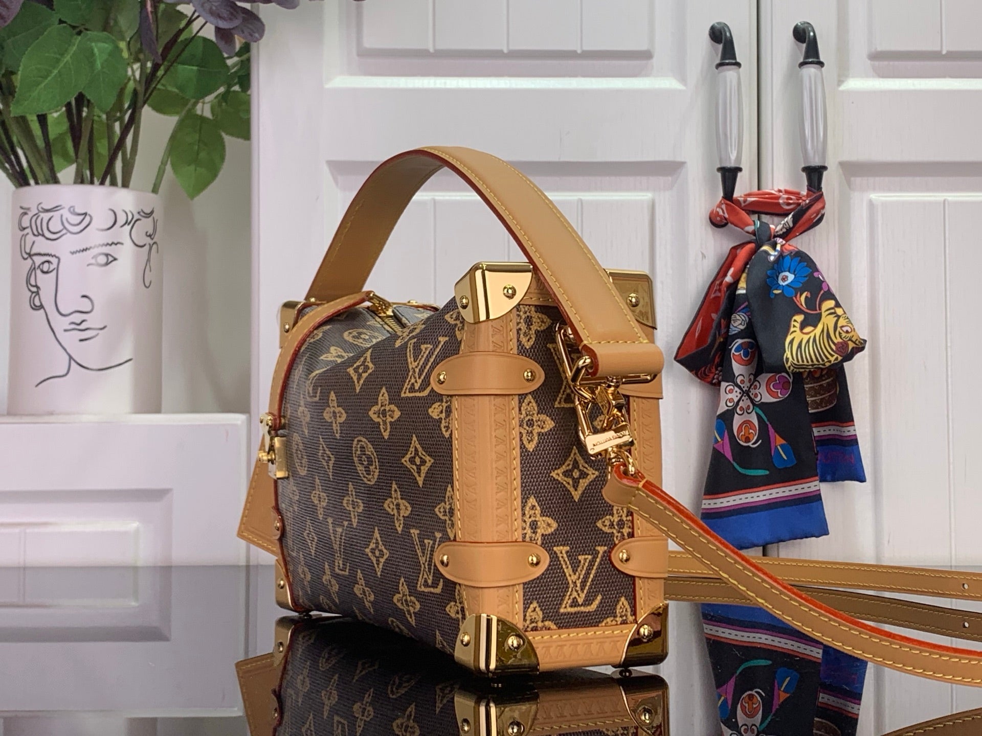 Louis Vuitton monogram satchel with tan top handle, side straps, and gold hardware