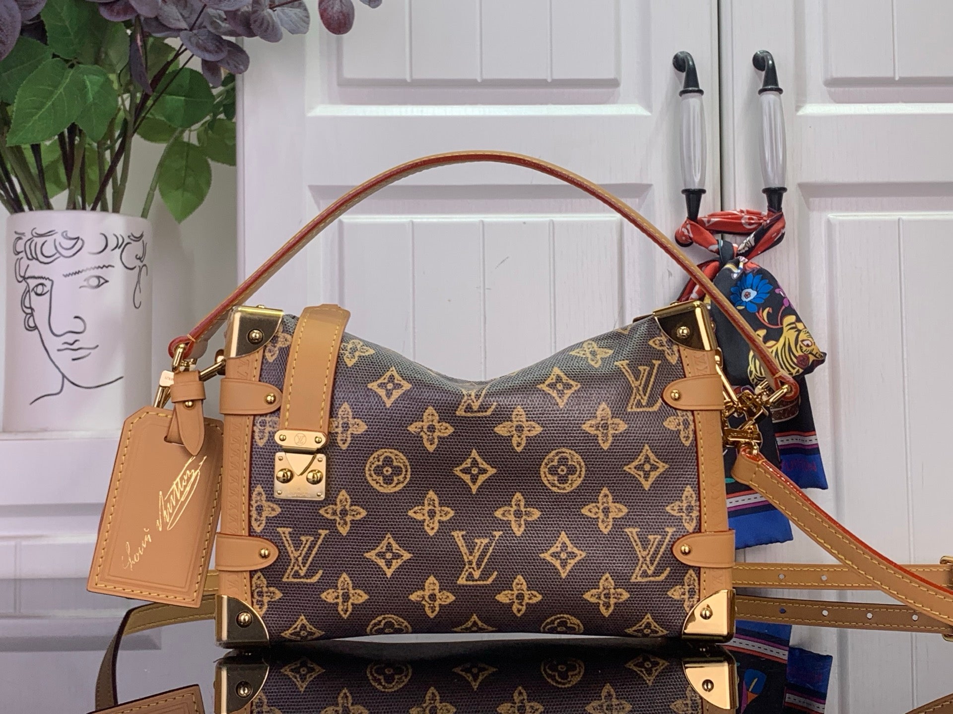 Louis Vuitton monogram handbag with tan leather straps and gold-tone hardware