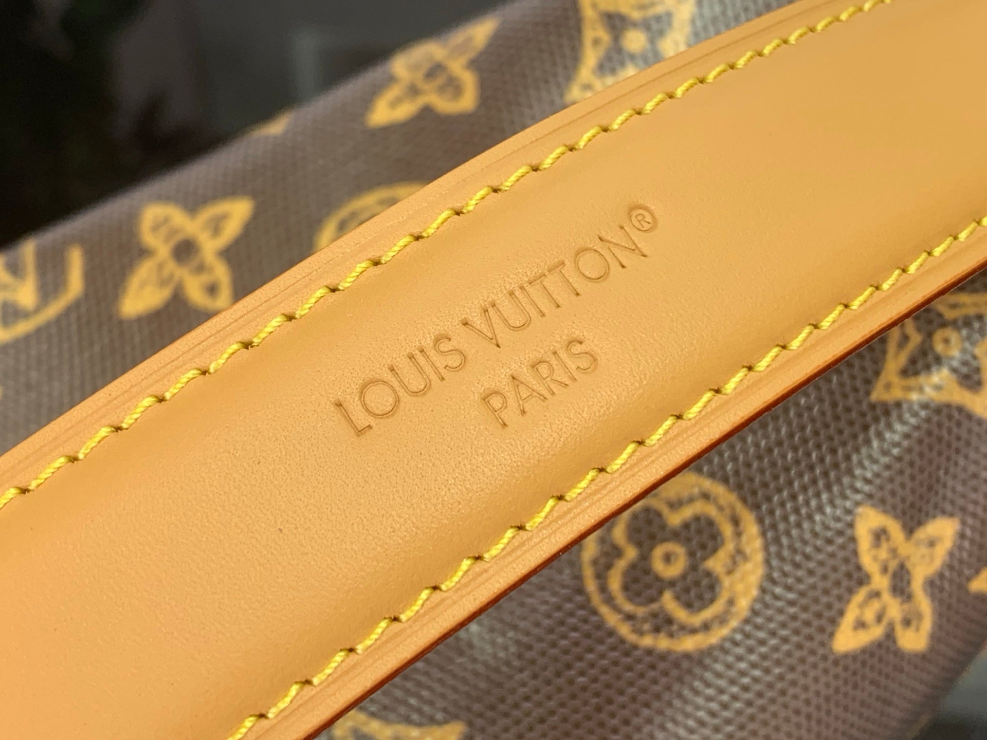 Louis Vuitton leather strap with embossed 'Louis Vuitton Paris' and yellow stitching