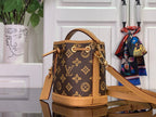 Monogram mini bucket bag with tan leather strap and front zipper pull charm