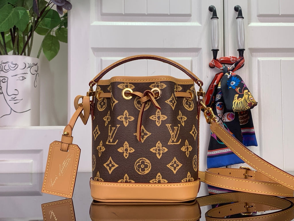 Monogram mini bucket bag with tan leather handles and crossbody strap