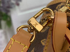 Gold-tone clasp hardware with tan leather tabs on a monogram bag strap