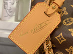 Tan leather luggage tag with stitched edge and cursive-style logo on monogram canvas