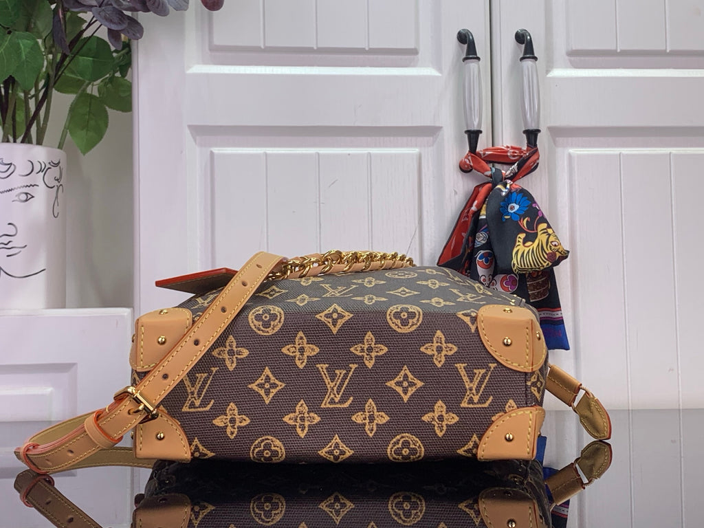 Monogram canvas bucket bag with tan leather straps and gold-tone chain handle