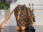 Monogram canvas bucket bag with tan leather drawstring and chain shoulder strap