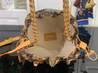 Monogram canvas bucket bag interior with tan leather logo patch and top edge