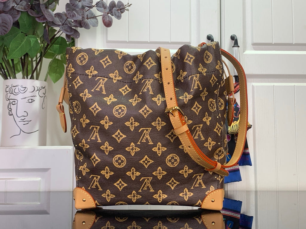 Monogram canvas bucket bag with tan leather handles and gold chain strap hardware