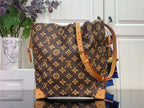 Monogram canvas bucket bag with tan leather handles and gold chain strap hardware