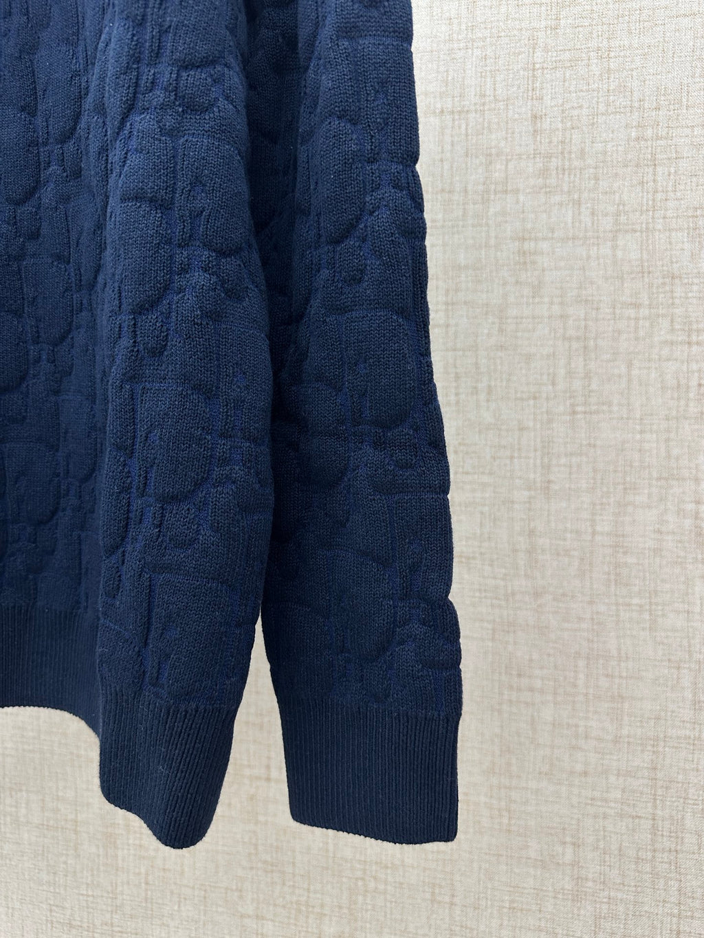 Navy knit sweater lower hem and ribbed cuffs, side view