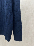 Navy knit sweater lower hem and ribbed cuffs, side view