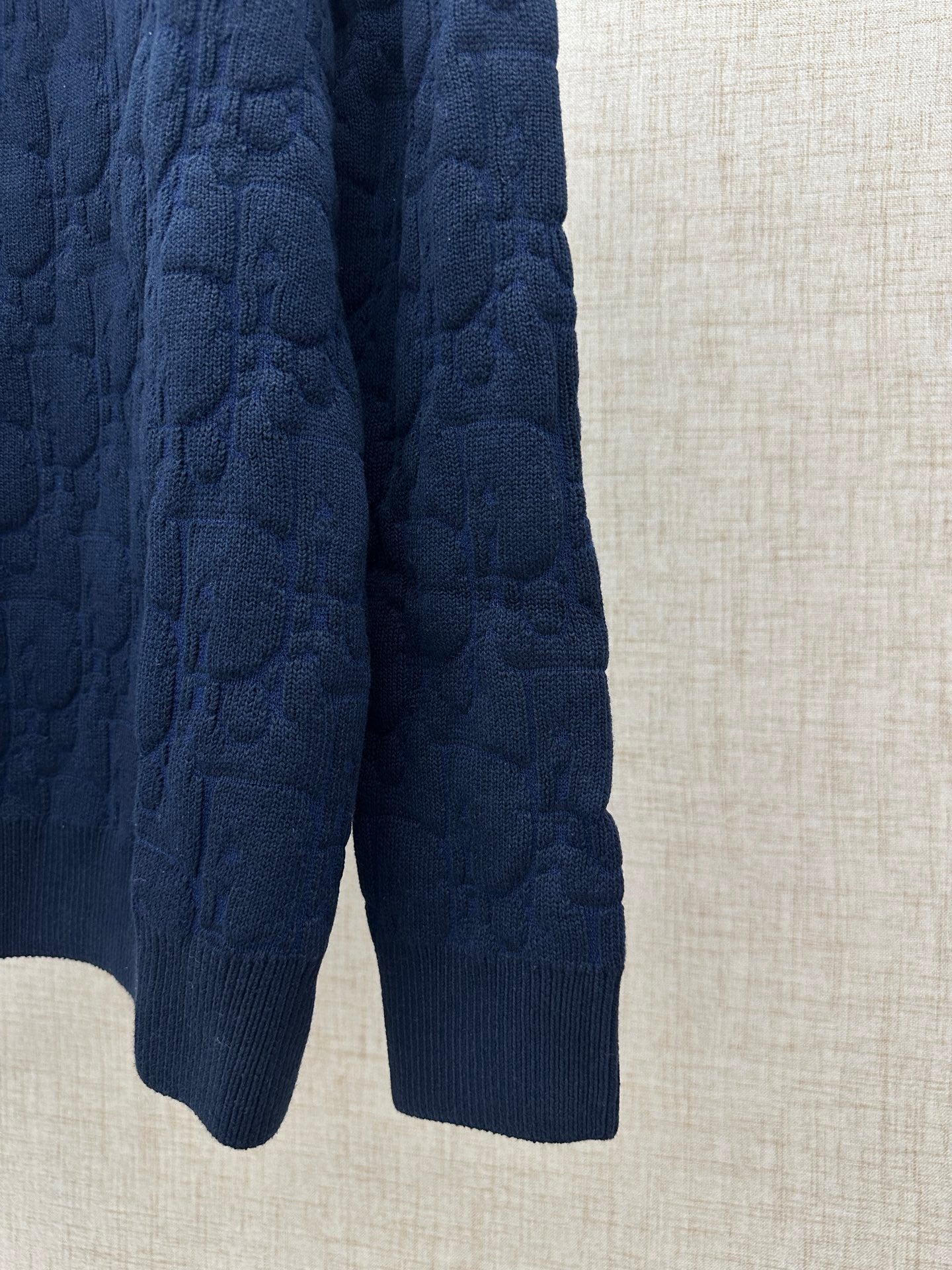 Navy knit sweater lower hem and ribbed cuffs, side view