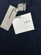 Navy knit sweater fabric close-up with Dior hang tag and size tag