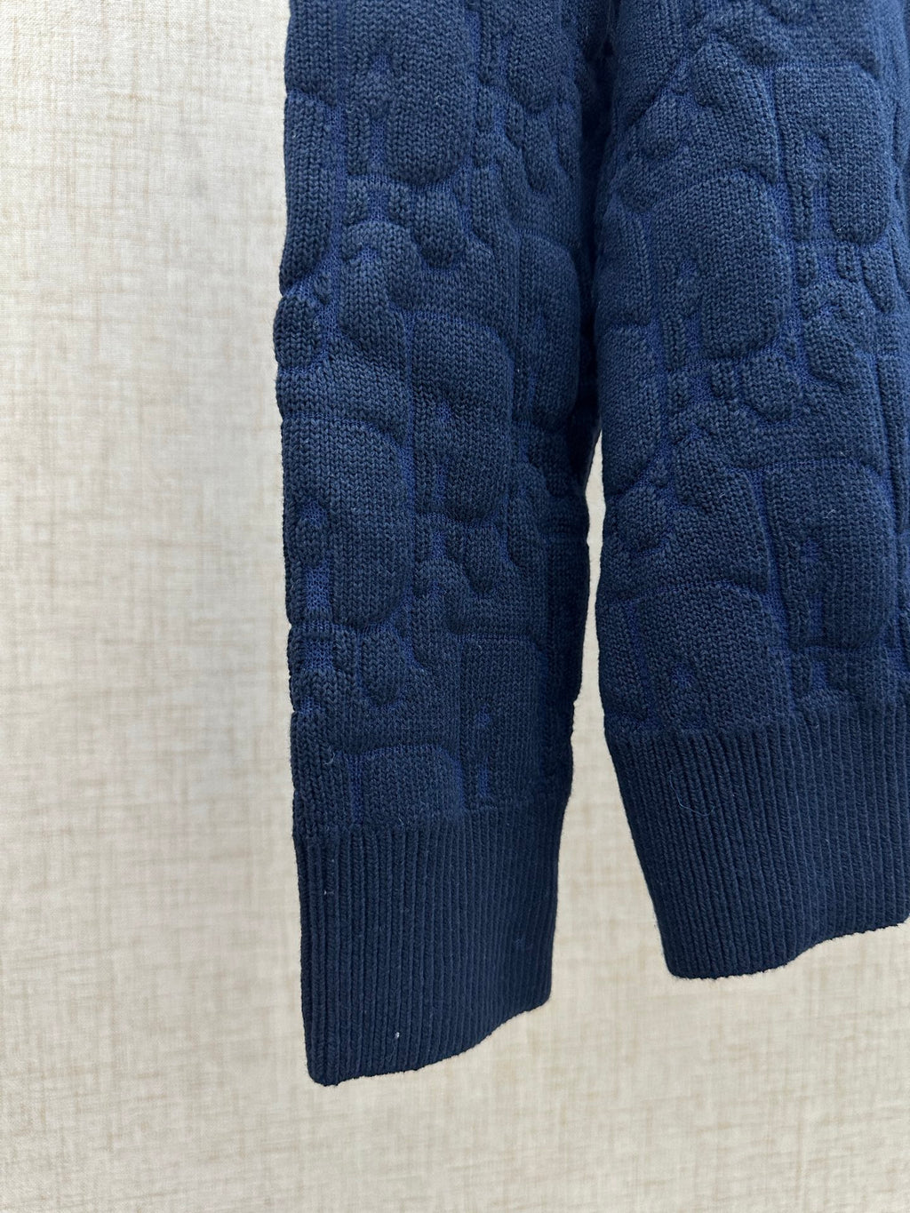 Navy knit sweater sleeves and hem, close-up view
