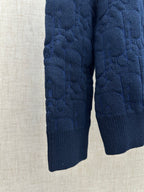 Navy knit sweater sleeves and hem, close-up view