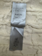 Cream sweater with attached size and material label on inner fabric