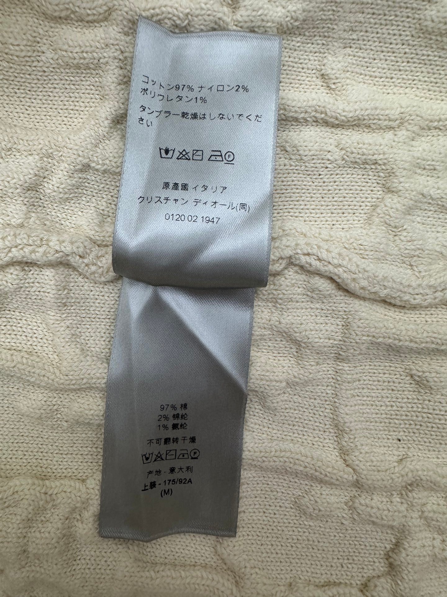 Cream sweater with attached size and material label on inner fabric