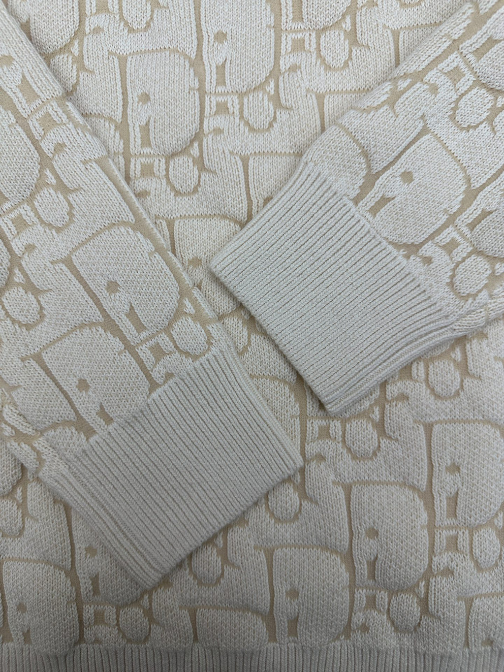 Cream ribbed knit cuffs and sleeves with allover logo pattern