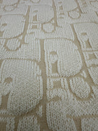 Cream knit fabric with allover geometric logo pattern texture