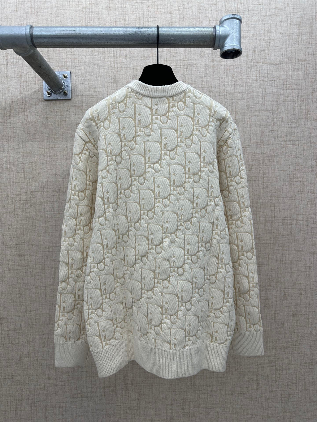 Cream knit sweater back view with allover logo pattern, ribbed crew neck and hem
