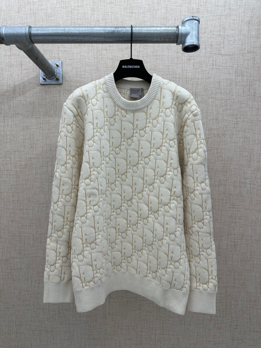 Cream knit sweater with allover logo pattern, ribbed crew neck and cuffs