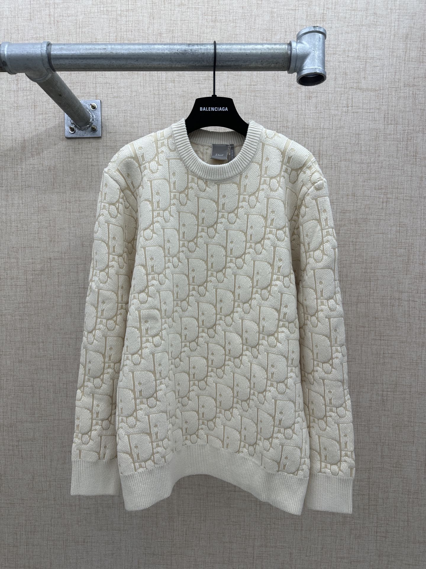 Cream knit sweater with allover logo pattern, ribbed crew neck and cuffs