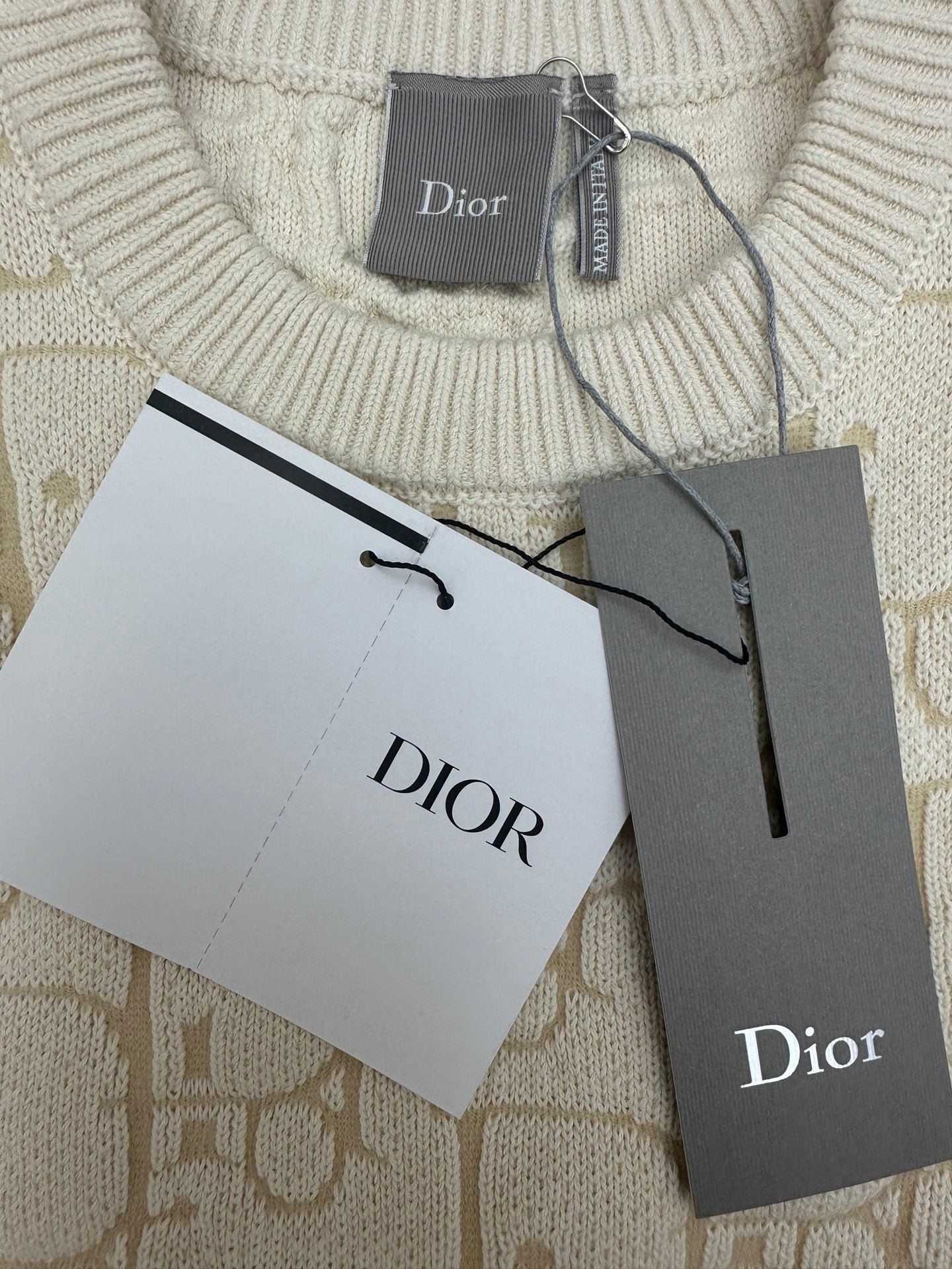 Cream ribbed crew neck sweater with Dior label and hanging retail cards