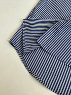 Striped button-up shirt, blue and white vertical stripes, folded with collar and sleeves