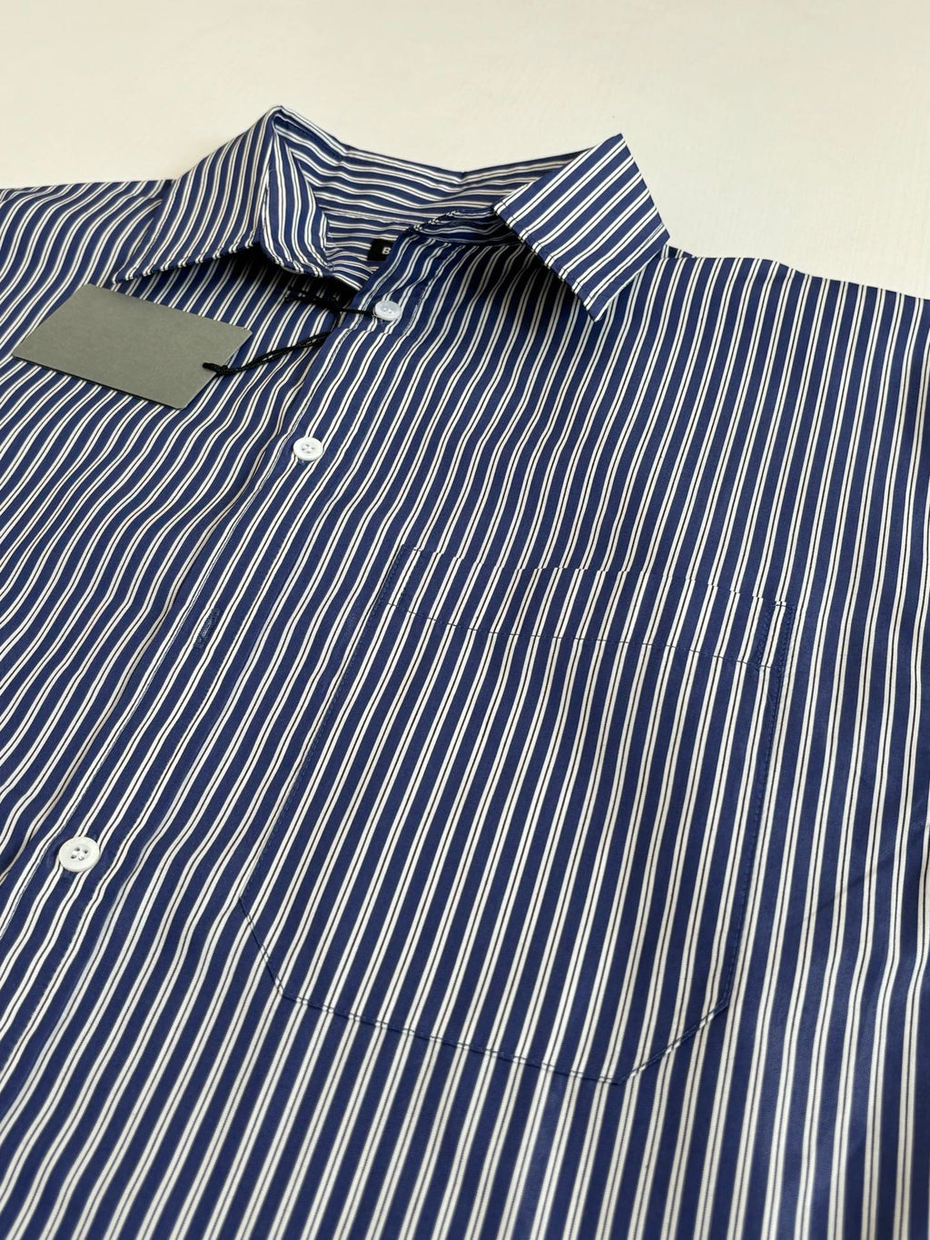 Striped button-up shirt detail, blue-and-white vertical stripes with button placket
