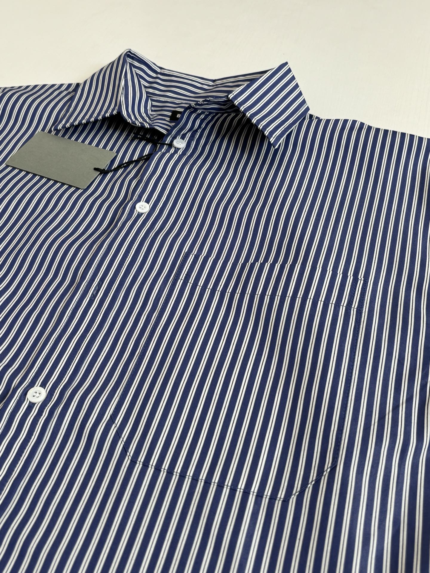 Striped button-up shirt detail, blue-and-white vertical stripes with button placket