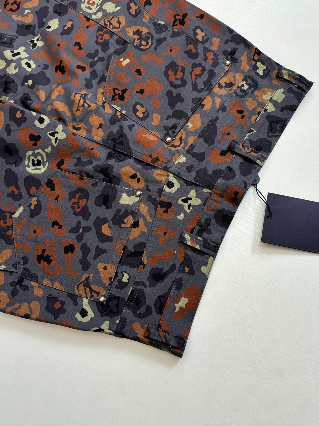 Louis Vuitton patterned shorts close-up, front button panel and welt pocket detail