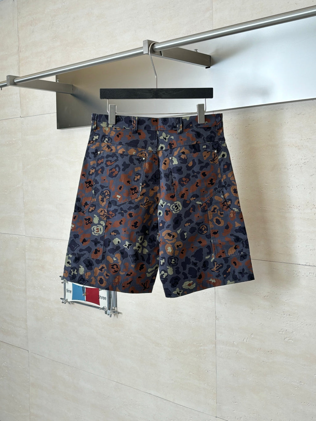 Louis Vuitton patterned shorts on hanger, front view, button fly and belt loops