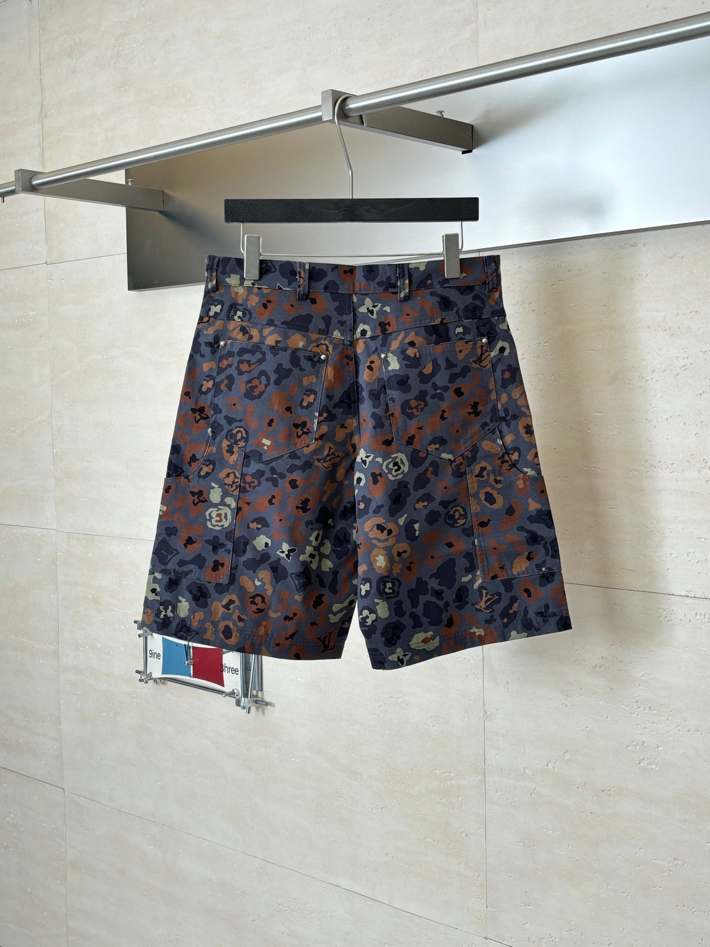 Louis Vuitton patterned shorts on hanger, front view, button fly and belt loops