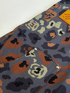 Louis Vuitton patterned shorts close-up, flap pocket with metal snap and logo patch