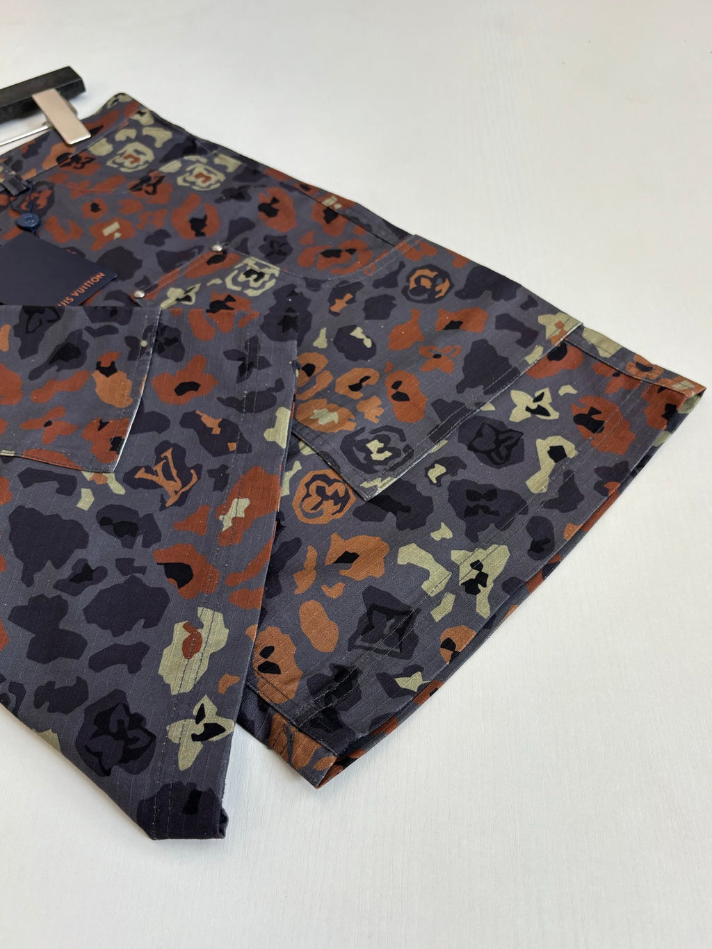 Louis Vuitton patterned shorts laid flat, side angle showing hem and camo print