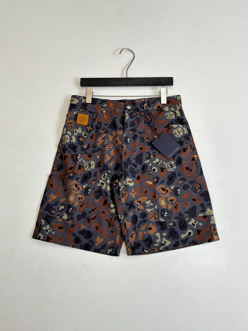 Louis Vuitton patterned shorts on hanger, all-over camo print, hang tag attached